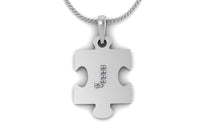 Image of a silver pendant in the shape of a puzzle piece with the letter ‘J’ in the middle 