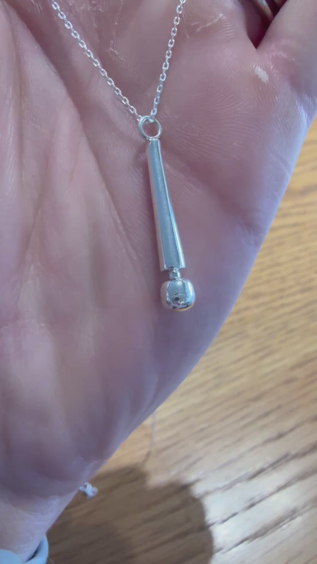 Video showing the solid sterling silver Magic Wand pendant catching light in hand.